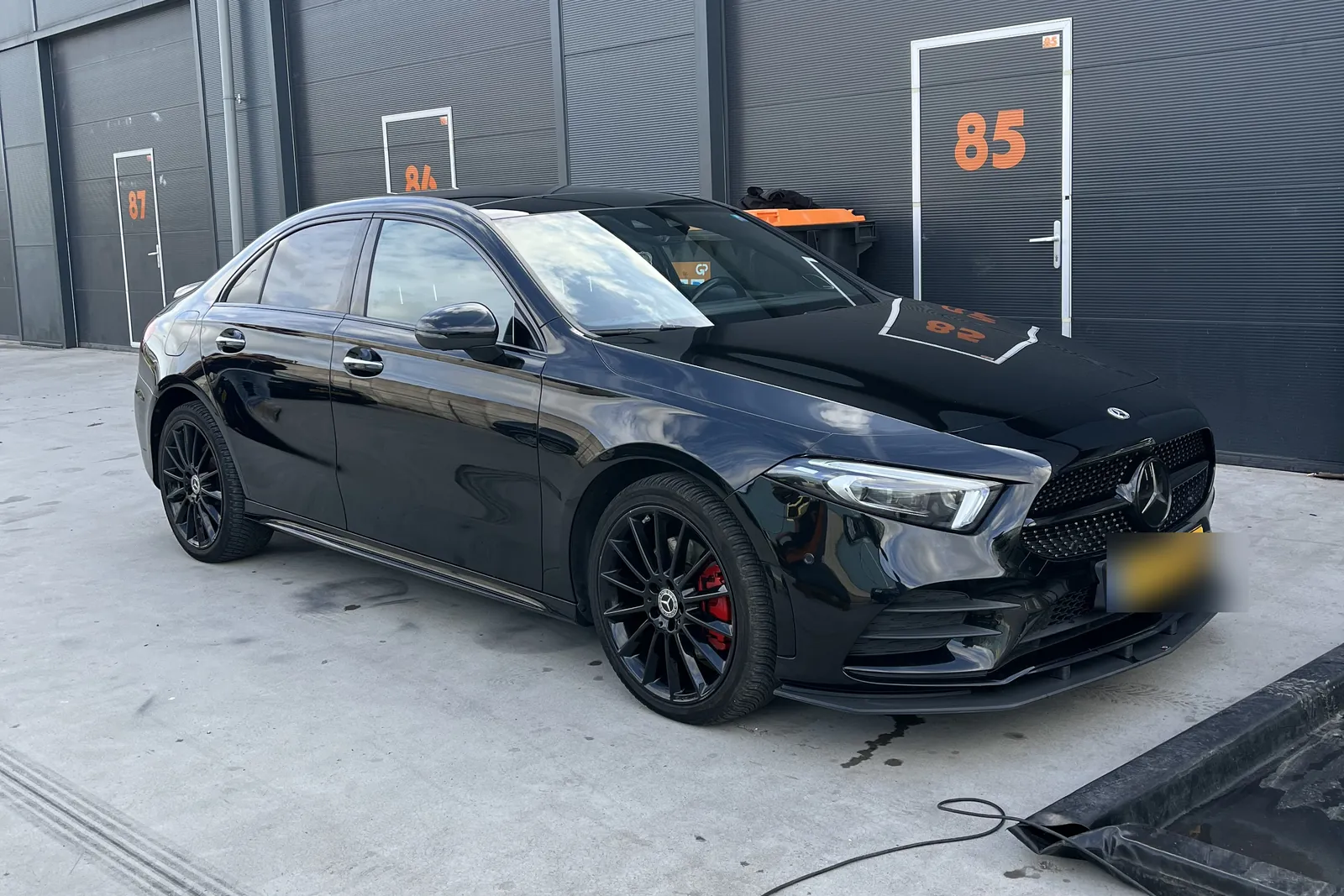 Dezelfde Mercedes na het verwijderen van de wrap, gitzwarte lak gepolijst